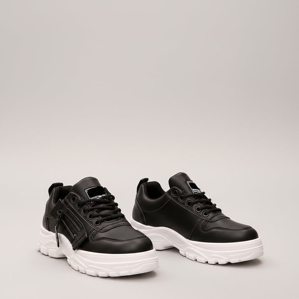 Black sneakers with white soles worn by a person on a street.