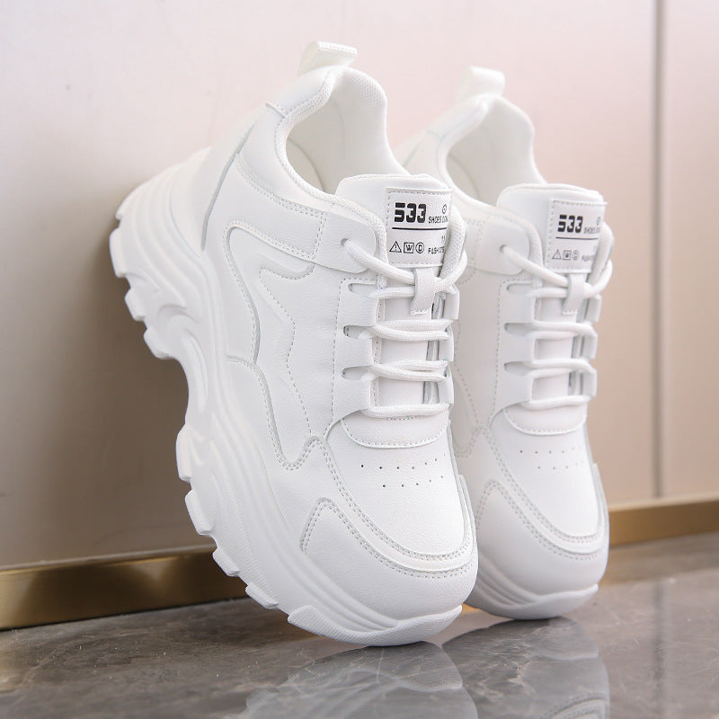 White sneakers with brand logo on a reflective surface