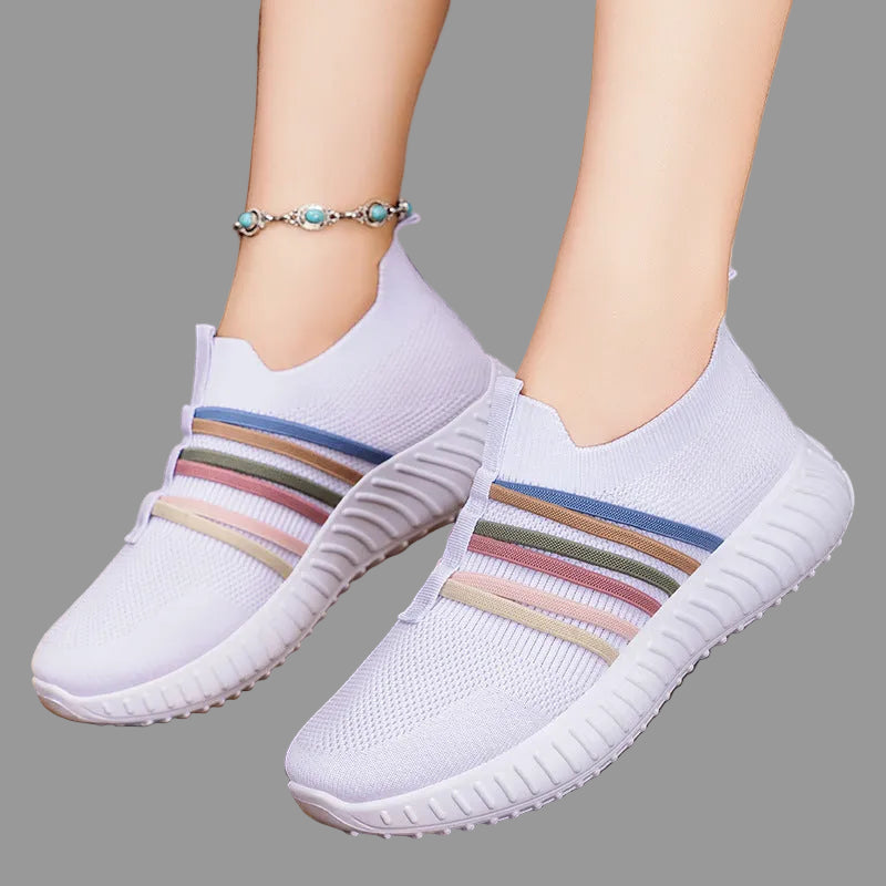 White sneakers with colorful stripes on a wooden floor