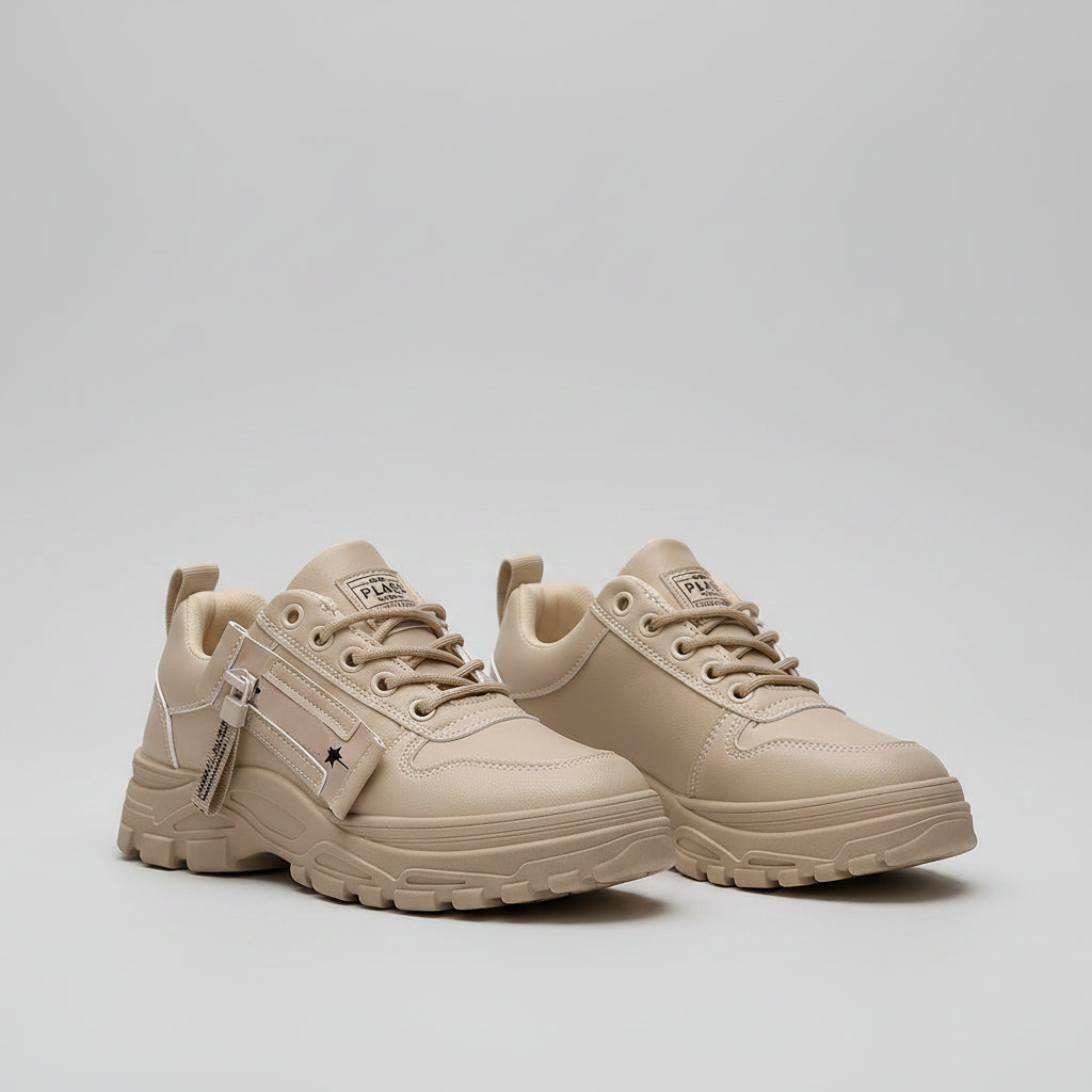 Beige sneakers worn with ripped jeans on a blurred background